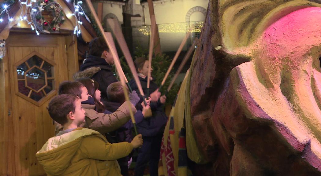 Els nens i nenes fan cagar el tió al Mercat de Nadal