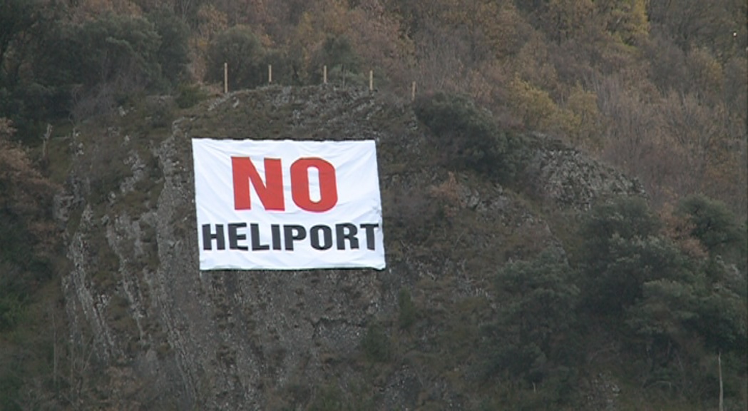 Pengen una pancarta reivindicativa en contra de l'heliport a la Comella